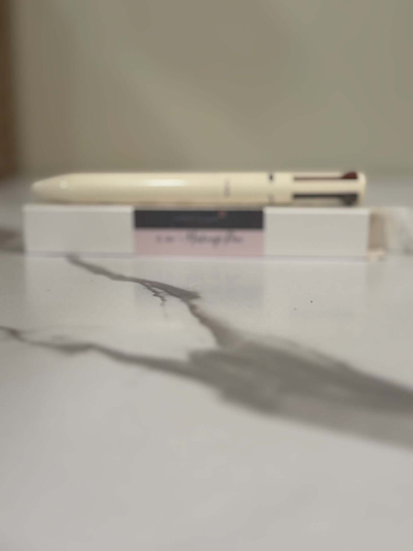4-in-1 makeup pen on a marble surface, showcasing compact beauty essentials for multi-use.