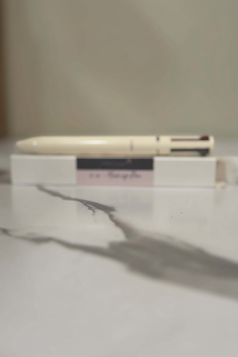 4-in-1 makeup pen on a marble surface, showcasing compact beauty essentials for multi-use.